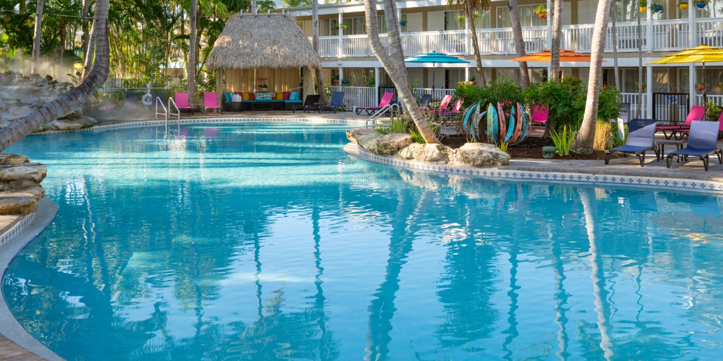 Havana Cabana pool with thatched cabanas and colorful loungers