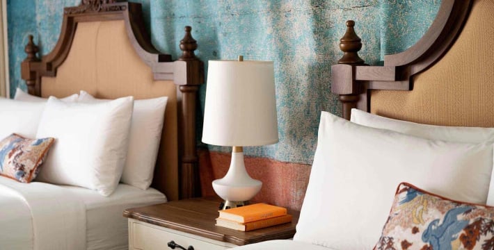 A close focus on the lamp placed on a shared bedside table in between the two queen beds