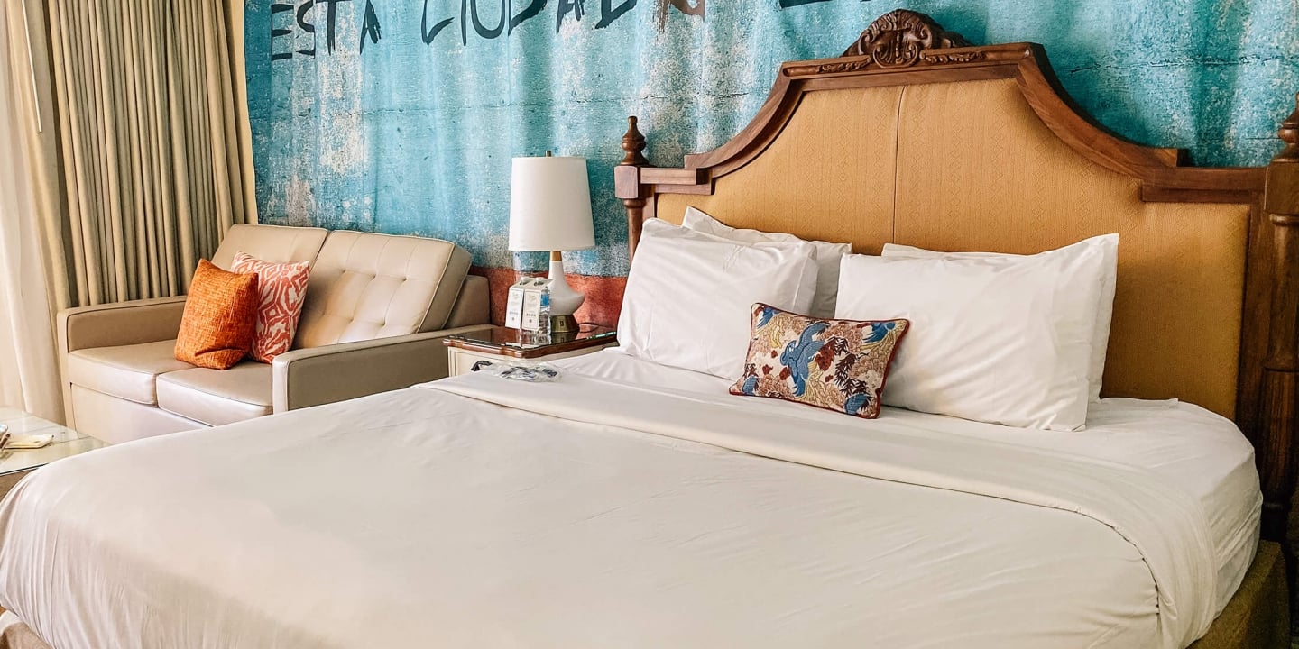 A side shot of the spacious bed next to leather couch at Havana Cabana