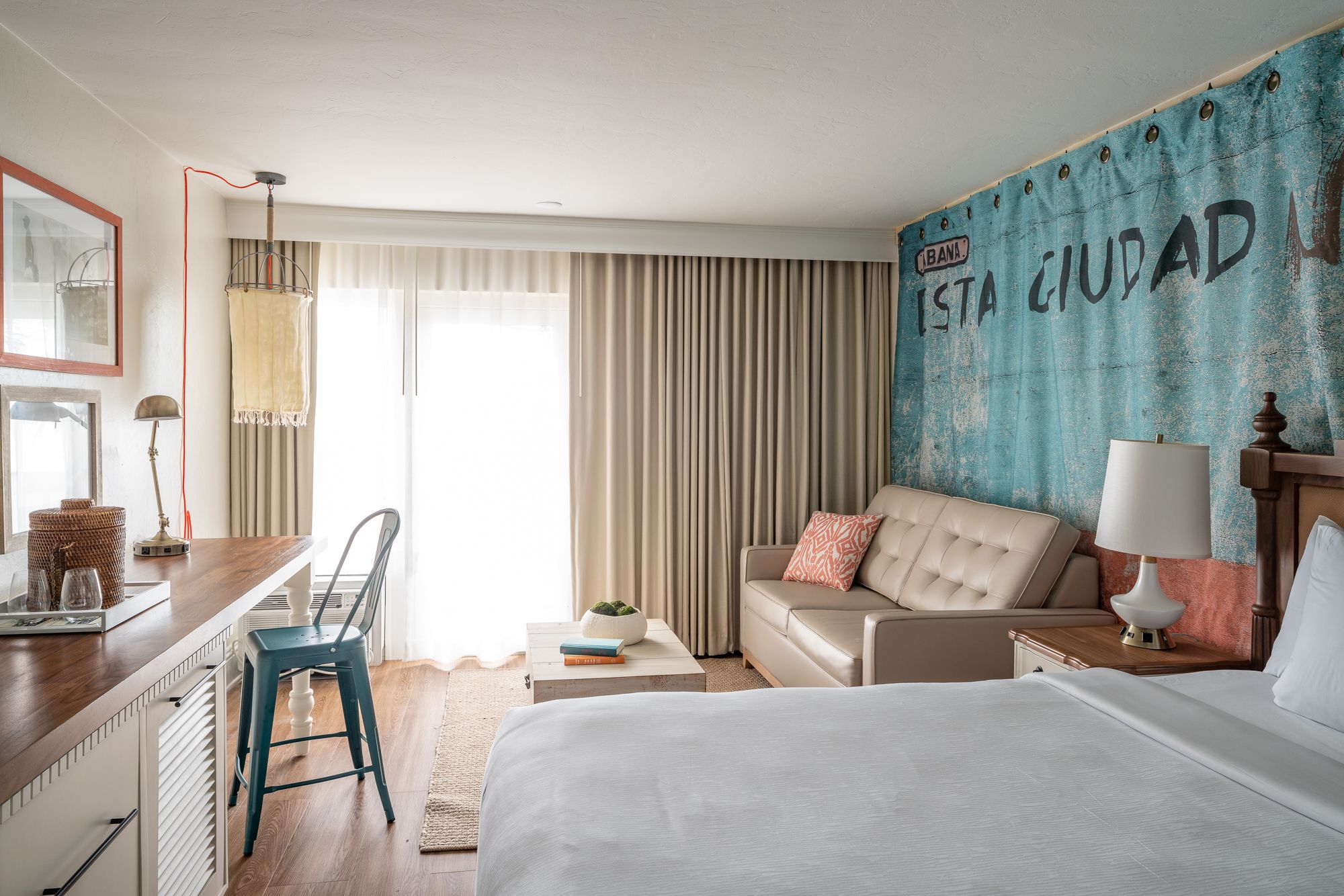Eight shirts arranged on table in black, olive, grey, blue, white, red, mustard, and green.