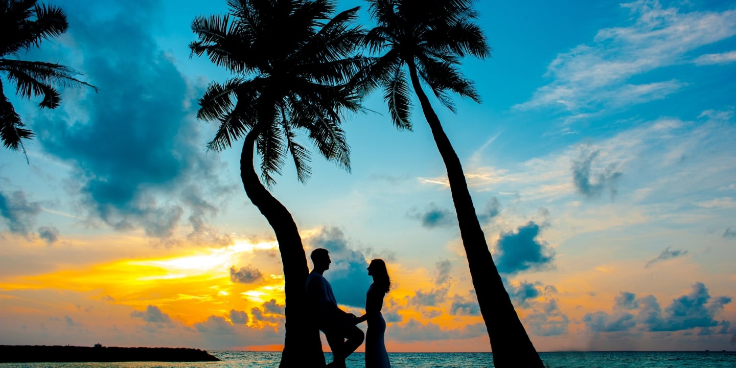 a couple on the beach during sunset