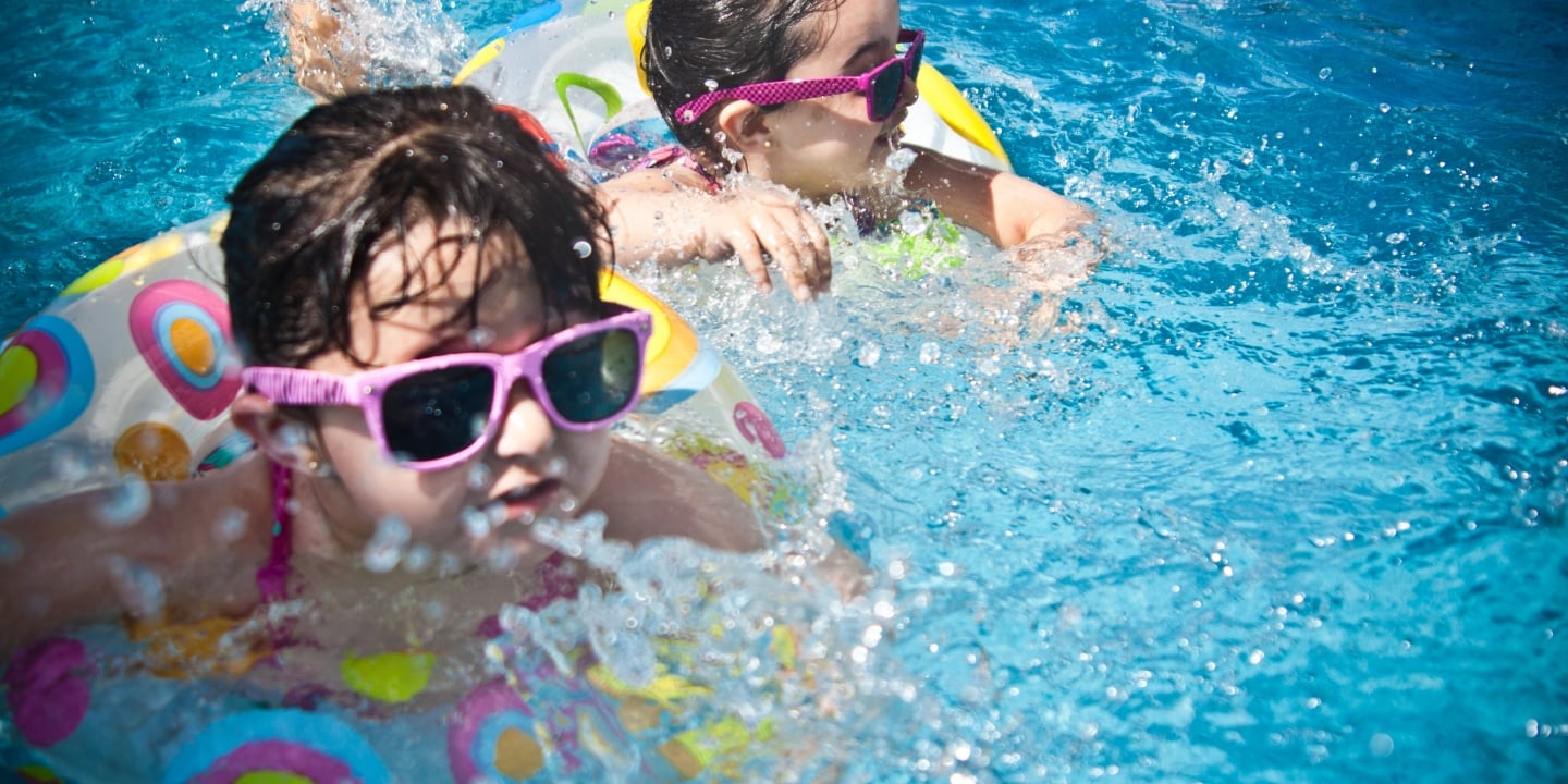 two kids floating in a pool